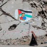 A woman walks past a mural depicting football player Lamine Yamal waving a Palestinian flag during the Catalans' title parade, painted by Palestinian artists on the rubble of buildings destroyed during the war, at Shati (Beach) refugee camp in Gaza City on May 13, 2026.