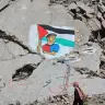 Una mujer pasa junto a un mural en el que aparece el futbolista Lamine Yamal ondeando una bandera palestina durante el desfile por el título de los catalanes, pintado por artistas palestinos sobre los escombros de edificios destruidos durante la guerra, en el campo de refugiados de Shati (Playa)