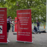 A demonstrator installs banners reading "WARNING - The artist you are about to see previously stated: 'I like Hitler' We thought you should know this," Arnhem, Netherlands, June 6, 2026. 