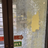 A photograph of the glass door at Haaretz smashed by a masked vandal. 