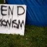 A sign that reads "end Zionism" leans against a tent, at a protest encampment in support of Palestinians, during the ongoing conflict between Israel and the Palestinian Islamist group Hamas, at Evergreen State College in Olympia, Washington, on April 28, 2024.