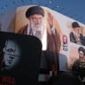 A poster of Benjamin Netanyahu with a message of revenge is carried by a demonstrator appears in front of a huge banner of Ayatollah Ali Khamenei as people gather to bid farewell to Iran's Supreme Leader Ayatollah Ali Khamenei in Revolution Square on July 6, 2026 in Tehran, Iran.