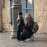 A father talking to his son on a winter morning in Jaffa street, both wearing protective masks, Jerusalem, November 5th, 2020