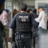 An ICE agent monitors hundreds of asylum seekers being processed upon entering the Jacob K. Javits Federal Building on June 6, 2023 in New York City; Illustrative.
