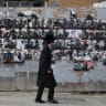 An Ultra-Orthodox Jewish youngster walks past a wall displaying posters of hostages, most of whom were kidnapped during the deadly October 7 attack by Hamas, in Stamford Hill, London.