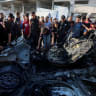 Palestinians inspect the site of an Israeli strike on a vehicle in Gaza City, July 8, 2026.