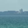 This frame grab taken from AFPTV video footage on July 12, 2026 shows a cargo ship anchoring near the Strait of Hormuz off the eastern coast of the United Arab Emirates at Khor Fakkan.