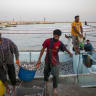  Fishermen unload their catch on May 16, 2026 along the Strait of Hormuz on Qeshm Island, Iran.