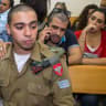 Israeli soldier Elor Azaria, who was caught on video shooting a wounded Palestinian assailant in the head as he lay on the ground, sits during a hearing at a military appeals court in Tel Aviv during which he was charged with manslaughter on April 18, 2016.