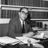 Sir Joshua Hassan CBE, MVO, QC, JP, Chief Minister of Gibraltar at his desk.