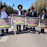 Haredi protesters holding signs asking US President Donald Trump to save them from being drafted, July 15, 2026.
