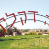 GUSH KATIF’S pioneers made the desert bloom: Entrance to Neveh Dekalim, seen July 2005.