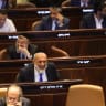 Shas leader Arye Deri smiles from his seat in the Knesset, July 16, 2026.