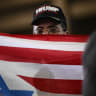 A supporter holds a combination US and Israeli flag as the US president speaks about the economy at Rockland Community College Fieldhouse in Suffern, New York, on May 22, 2026. 