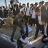 Ultra-Orthodox Jewish men block a road during a protest against the jailing of seminary students who failed to comply with an army recruitment order on Road 4 near Bnei Brak, July 16, 2026.
