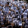 People hold images of the victims of the 1994 bombing attack on the Argentine Israelite Mutual Association (AMIA) community centre, marking the 31st anniversary of the attack, in Buenos Aires, Argentina July 18, 2025