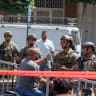 A man on a motorcycle tries to convince Lebanese army officers to let him cross as they cordon off the site of an Israeli strike in the southern suburbs of Beirut, Lebanon, June 14, 2026. 
