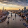 Panoramic aerial view of the skyline of London, England, with Tower Bridge, River Thames and City skyscrapers during a colorful sunset.