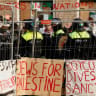 Police officers stand next to pro-Palestinian protesters outside the University of Amsterdam during a protest, in Amsterdam, Netherlands, May 8, 2024
