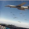 US Air Force Rockwell B-1B Lancer dropping JDAM bombs photographed from the canopy of an escort fighter jet.