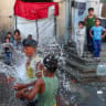 Displaced Palestinian children play in water as they shelter at a school on a hot day, in Khan Younis, in the southern Gaza Strip, July 1, 2026.