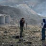 An Al Jazeera Arabic journalist broadcasts, while Syrians examine the aftermath of powerful Israeli airstrikes that targeted missile and weapons depots at a former Syrian military base, which residents said was also used by Russia, on December 16, 2024.