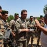 Lebanese army officers speak with villagers waiting to return to their homes at the entrance to Zawtar al-Gharbiyeh, a village in southern Lebanon.