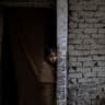 Rubaha, 8, watches from the entrance of her home as a buffalo is held down for sacrificial slaughter in celebration of Eid al-Adha in the Walled City of Lahore, Pakistan, June 8, 2025. 