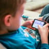  A kid plays on a phone. 