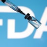 A US Food and Drug Administration (FDA) logo, a syringe and a vial are seen in this illustration taken May 13, 2025.
