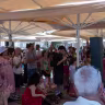 A crowd gathers to listen to Oren Pesso and his daughter Renee perform at Hatachana Park in Tel Aviv, July 24, 2026.