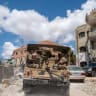 Lebanese army officers on a military vehicle drive in Zawtar al-Gharbiyeh, a village in southern Lebanon, following the deployment of Lebanese soldiers in one of three pilot zones after the withdrawal of Israeli forces under a US-brokered plan, July 26, 2026. 