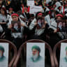 People hold posters depicting Hezbollah chief Naim Qassem and Iran's late Supreme Leader Ayatollah Ali Khamenei, who was killed on February 28 in Israeli and US airstrikes, as people gather to mourn him, in the southern suburbs of Beirut, Lebanon, July 8, 2026.