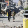 Palestinians walk next to yellow concrete block marking the “yellow zone” under Israeli military control in the Tufah neighborhood of Gaza City, July 27, 2026. 