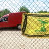 A flag with the pattern of the Hezbollah flag hangs on a fence as residents wait to enter the town of Zawtar al-Gharbiyeh, following the withdrawal of Israel forces under a U.S.-brokered plan, in southern Lebanon, July 25, 2026. 