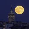 A full moon rises behind the Galata Tower in Istanbul, Turkey, July 29, 2026.