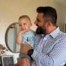 Ramin Parsa holds his child in their family home in Israel