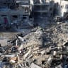 Palestinians inspect the site of an Israeli strike on a house that was pre-warned by the Israeli military to evacuate before the strike was carried out late on Wednesday, in Al-Nuseirat refugee camp, in the central Gaza Strip, July 16, 2026.