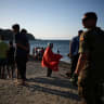 Migrants stand on a beach in Ceuta, following mass crossings of migrants on foot and by sea from Morocco into Spanish territory, in Ceuta, Spain, August 2, 2026.
