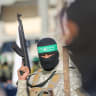 Palestinian militant group Hamas fighters secure an area before handing over two Israeli hostages to a Red Cross team in Khan Yunis.