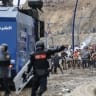 Moroccan security forces clash with migrants attempting to cross into Spain's North African enclave of Ceuta near the town of Fnideq, on the Morocco-Spain border, on July 31, 2026. 