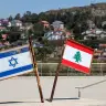 Representations of the Israeli and Lebanese flags at a memorial near the Israel-Lebanon border, after Israel and Lebanon signed a framework agreement following US-mediated talks, as the town of Metula, Israel, appears in the distance, June 27, 2026; illustrative.