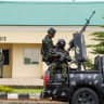 Armed military men keep watch from a military truck during a public destruction exercise at the Muhammadu Buhari Cantonment in Abuja, Nigeria, July 30, 2026.