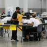 An election worker holds an envelope containing ballot stubs at a polling station during the Michigan primary elections, in Detroit, Michigan.