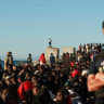 Migrants wait in line to receive food and beverage from the Red Cross, following mass crossings of migrants on foot and by sea from Morocco into Spanish territory, in Ceuta, Spain, August 3, 2026. 
