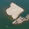 A drone view shows people swimming near a sunken German warship from World War II, exposed due to low Danube River levels caused by drought and extreme heat, in Prahovo, Serbia, July 30, 2026. 