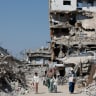 Palestinians walk past the rubble of residential buildings destroyed during the war, at Jabalia refugee camp in the northern Gaza Strip, August 5, 2026.