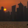 The sun sets behind the Doha skyline on August 4, 2026. 