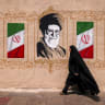 A woman walks past a mural depicting Iran’s late supreme leader Ali Khamenei in Tehran in August.