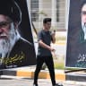 An Iranian Shiite Muslim pilgrim walks past banners of Iran's slain supreme leader Ali Khamenei and his son, the current supreme leader Mojtaba Khamenei, as he enters Iraq through the Shalamjah (Shalamcheh) border crossing in Basra province On July 23, 2026; illustrative